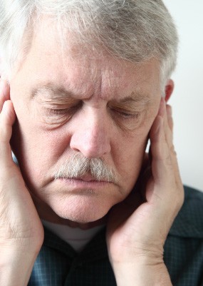 Man holding jaw in pain before T M J treatment