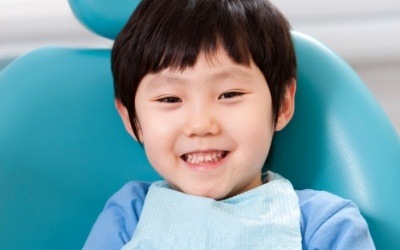 Child with big smile in dental treatment chair