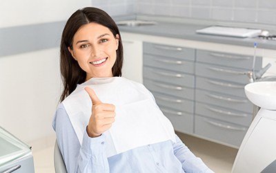 Female patient smiling and giving a thumbs up