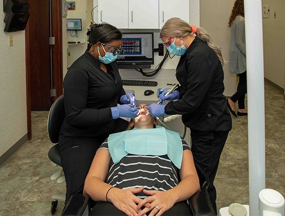 Dental team members placing veneers