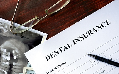 a dental insurance form on a wooden table