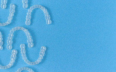 Clear aligners lying on blue background
