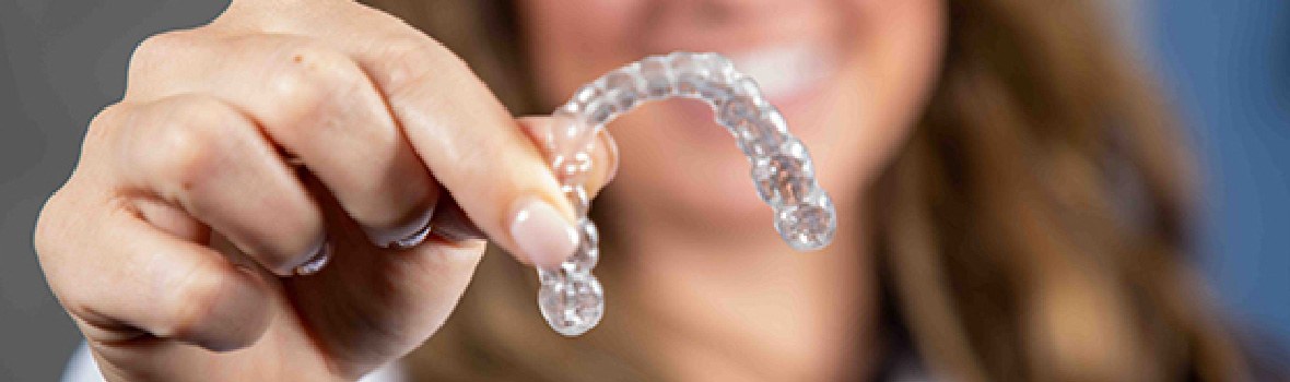 woman holding invisalign