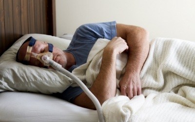 Man sleeping with a sleep apnea device