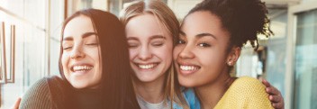 Three young women smiling after Invisalign treatment