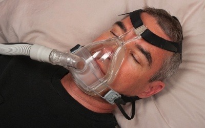 Man wearing sleep apnea device
