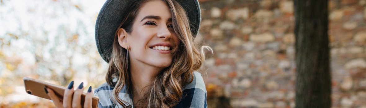 woman smiling holding cell phone