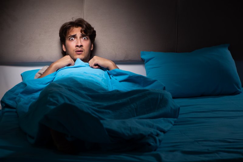 A frightened young man who just woke up from a nightmare