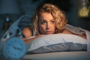 Woman struggling to sleep due to sleep apnea